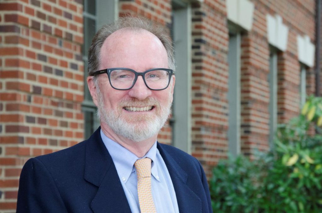 Dr. Crooke, Senior Associate Dean of Faculty and Academic Affairs, smiling in front of the Medical-Dental Building.